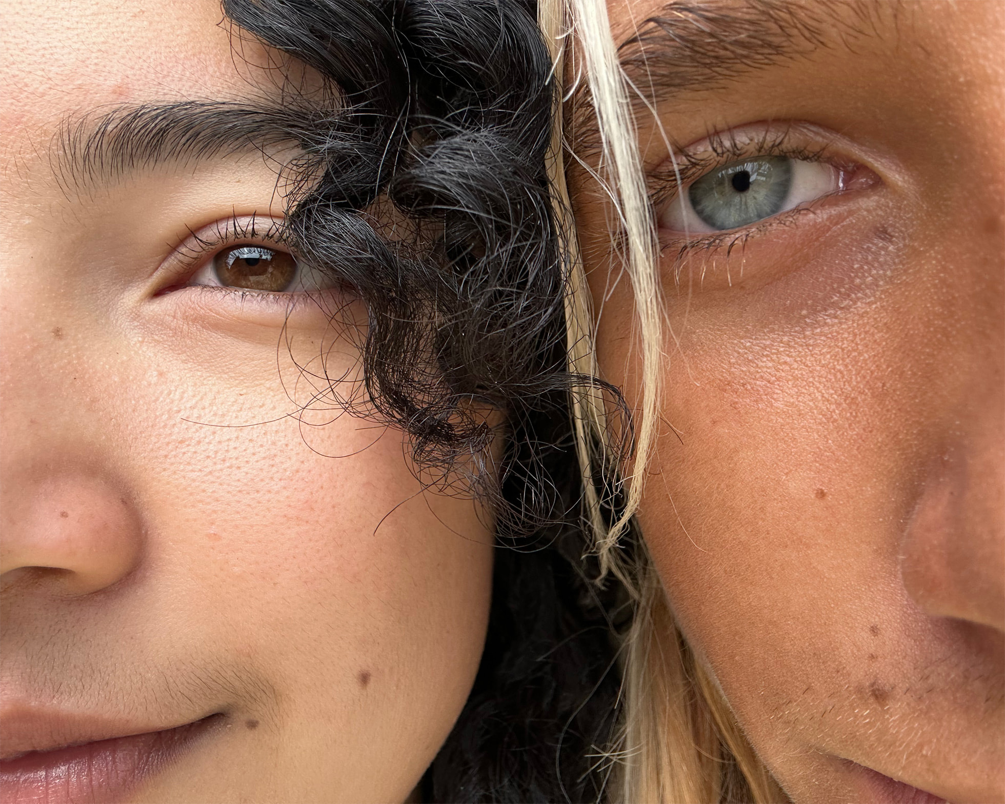 Photo de près de deux visages de personnes côte à côte, l'une aux yeux bleus et l'autre aux yeux marrons