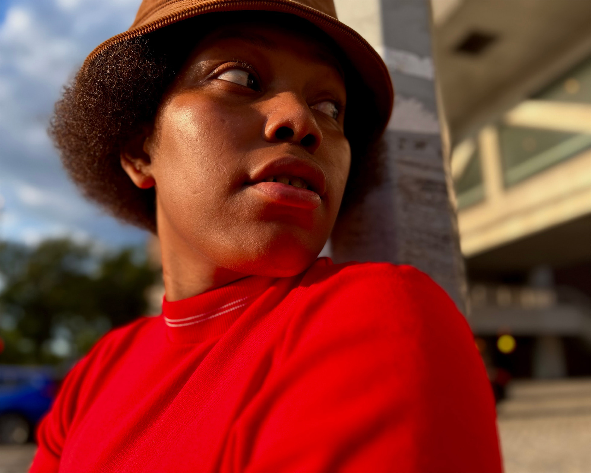 Portrait d'une femme portant un chapeau de paille et un pull rouge