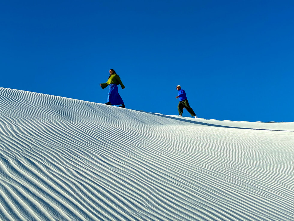 Deux skieurs sur une crête enneigée par un beau ciel bleu