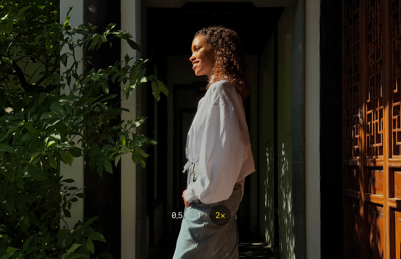 photo femme souriante de profil avec des plantes dans un couloir